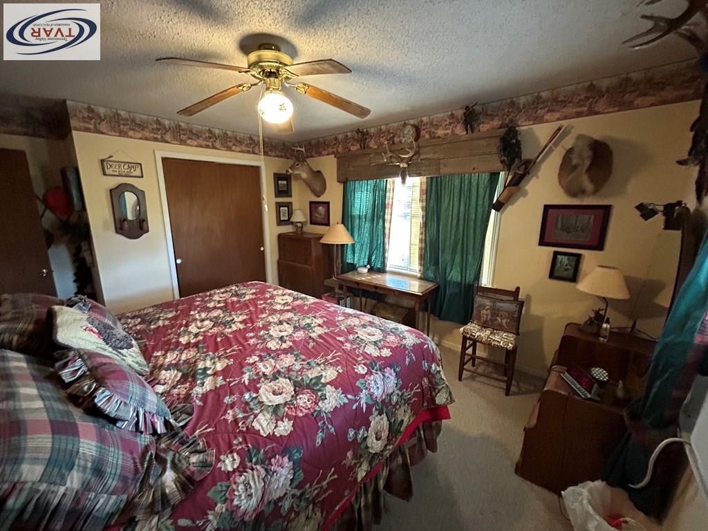 4460 Point Mason Road Big Sandy, TN 38221 - Photo 18 of 22 a bedroom with a bed and a chandelier