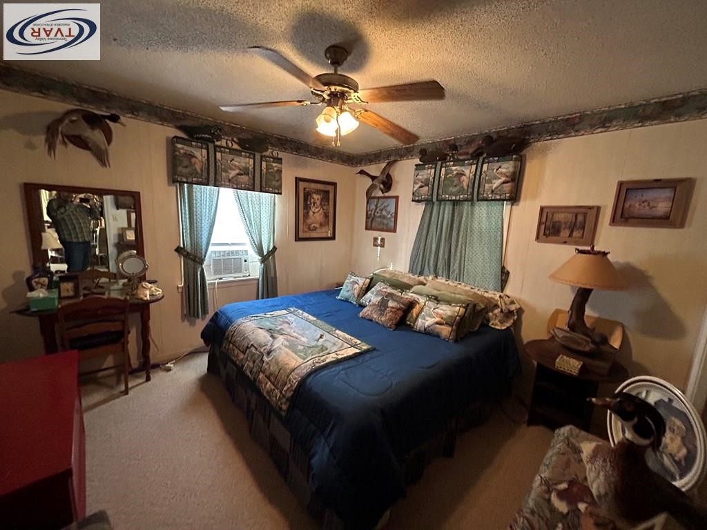 4460 Point Mason Road Big Sandy, TN 38221 - Photo 19 of 22 a bedroom with a bed and a chandelier