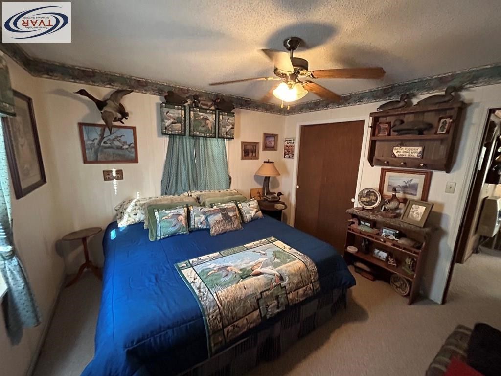 4460 Point Mason Road Big Sandy, TN 38221 - Photo 20 of 22 a spacious bedroom with a bed and a chandelier