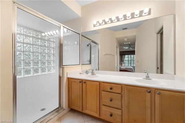 a bathroom with a double vanity sink and mirror with shower
