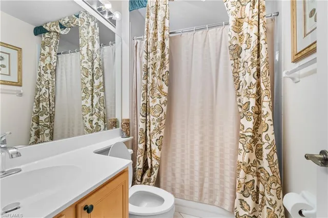 a bathroom with a sink a toilet and shower curtain