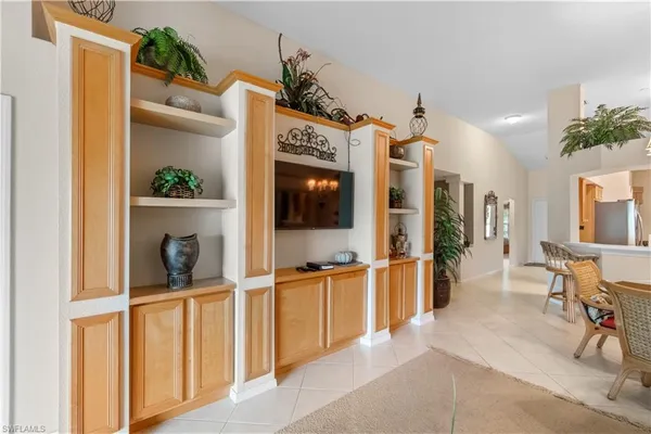 a living room with furniture a flat screen tv and large window