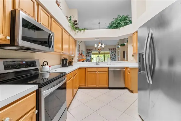 a kitchen with stainless steel appliances granite countertop a refrigerator a stove top oven a sink and dishwasher