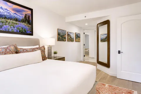 a bedroom with a large bed and a painting on the wall