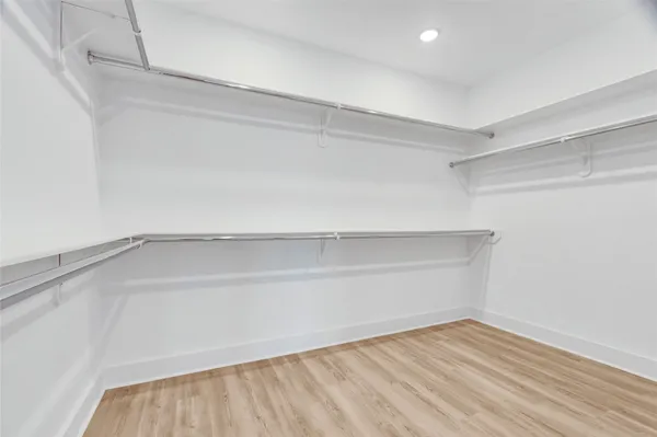 a view of walk in closet with wooden floor