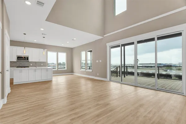 a large kitchen with stainless steel appliances granite countertop a refrigerator and a large window