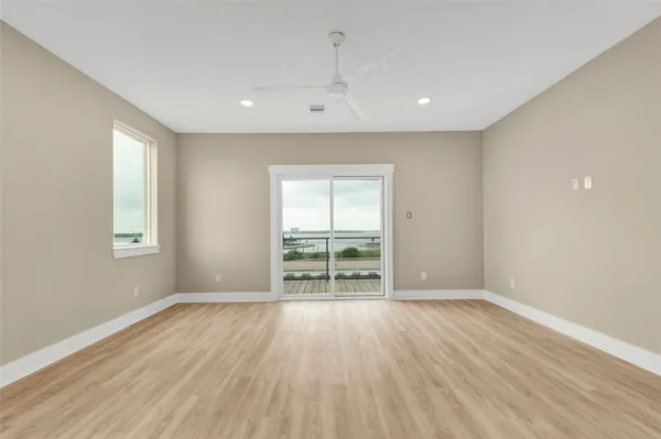 a view of an empty room with wooden floor and closet