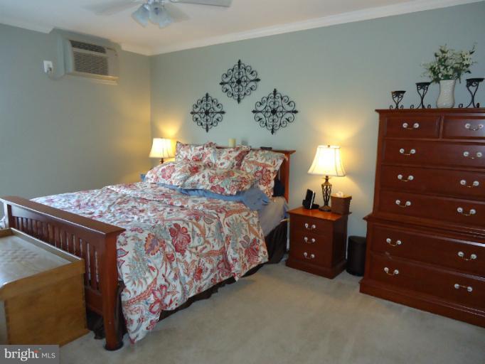 501 Prospect Boulevard, Unit A25 Frederick, MD 21701 - Photo 11 of 14 a bedroom with a bed and a lamp on dresser
