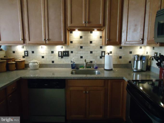 501 Prospect Boulevard, Unit A25 Frederick, MD 21701 - Photo 7 of 14 a kitchen with stainless steel appliances granite countertop a sink a stove and cabinets