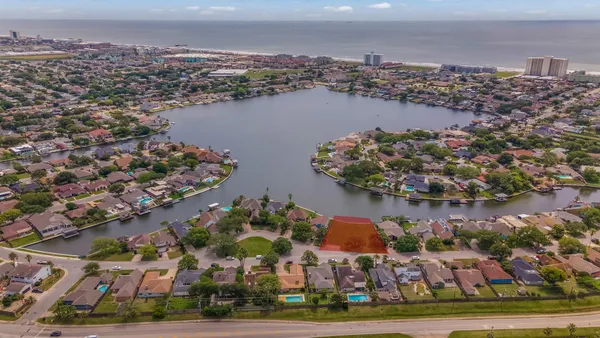 an aerial view of residential houses with outdoor space and lake view