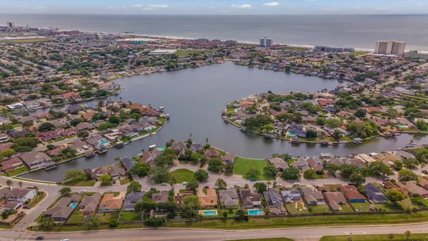 an aerial view of residential houses with outdoor space and lake view