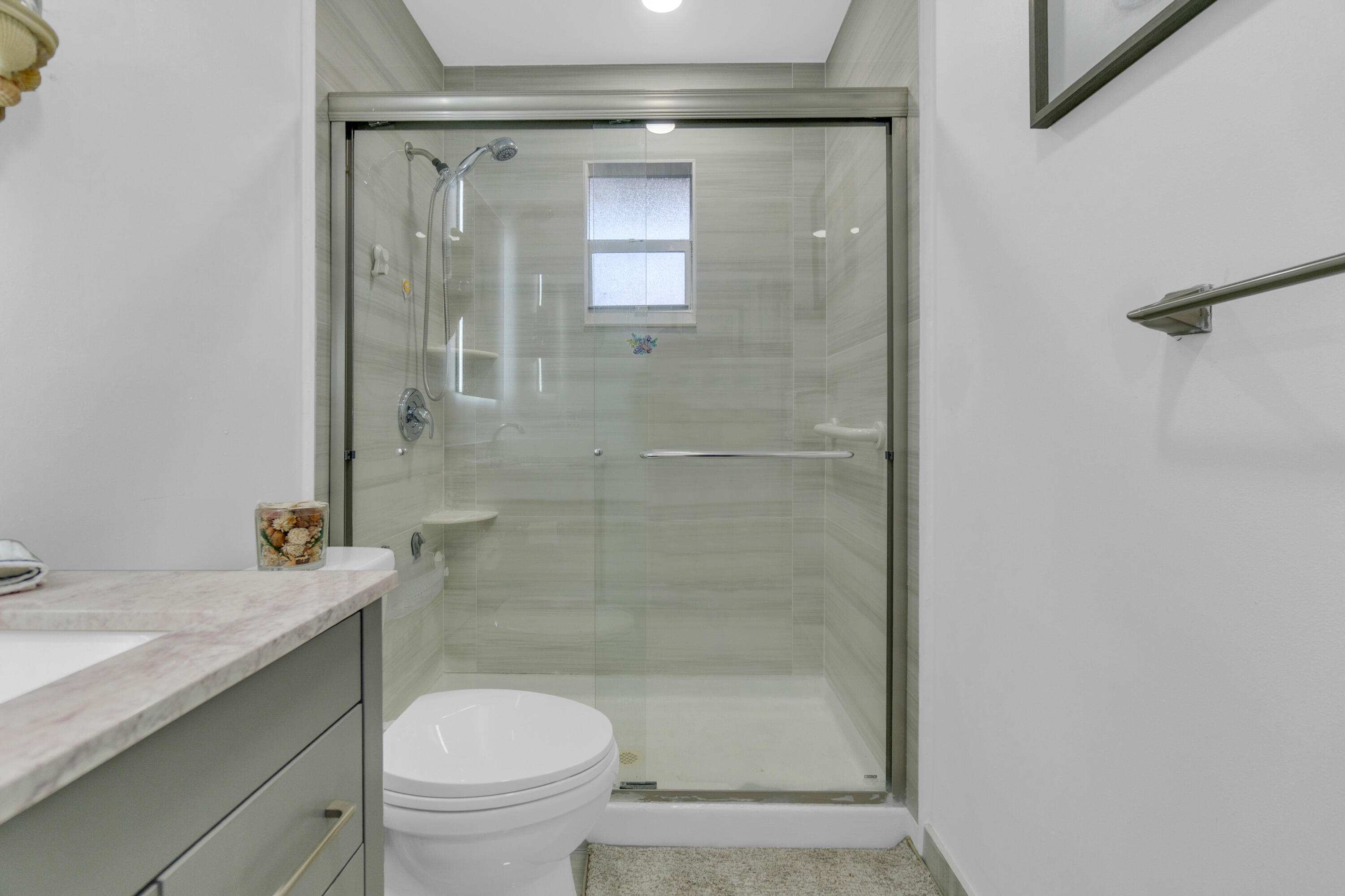 504 Davis Road, Unit 86 Palm Springs, FL 33461 - Photo 12 of 25 a bathroom with a granite countertop toilet a sink and shower