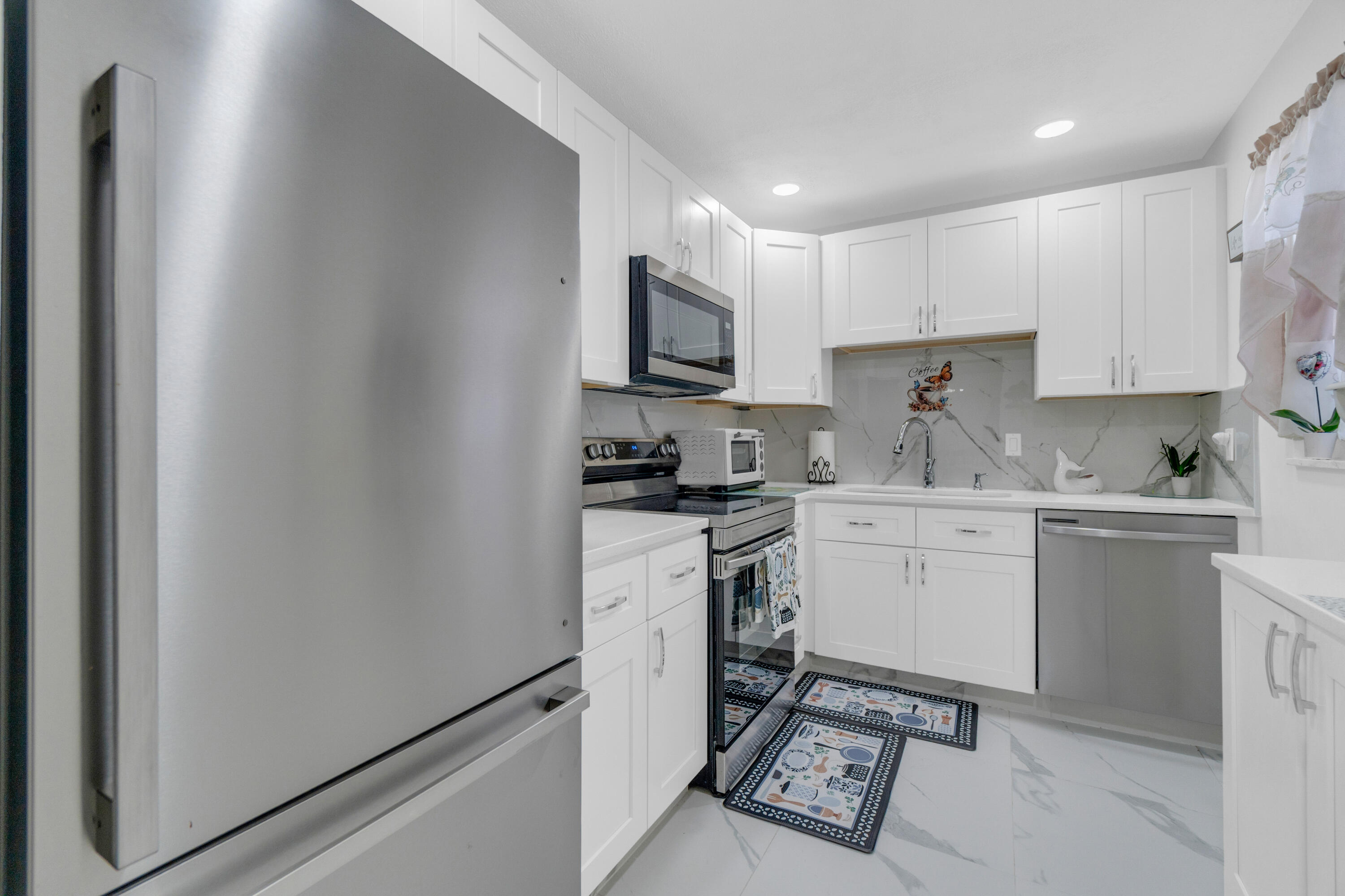 504 Davis Road, Unit 86 Palm Springs, FL 33461 - Photo 4 of 25 a kitchen with granite countertop white cabinets sink and stainless steel appliances