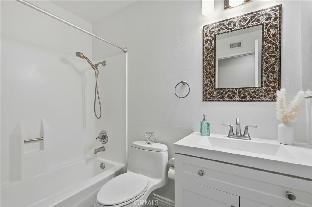 25868 Alegro Drive Valencia, CA 91355 - Photo 21 of 35 a bathroom with a sink mirror vanity and toilet