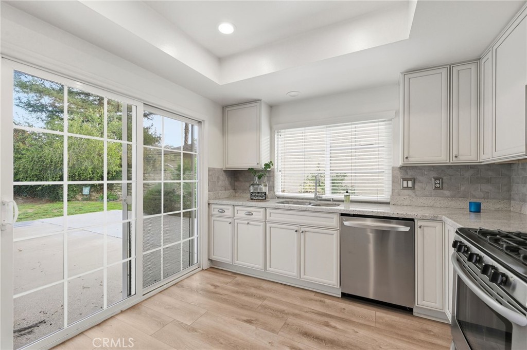 25868 Alegro Drive Valencia, CA 91355 - Photo 9 of 35 a kitchen with stainless steel appliances granite countertop a stove a sink and a microwave