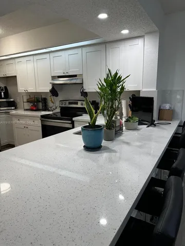 a kitchen with a sink a stove and cabinets
