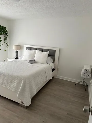 a large bed sitting in a room next to a lamp