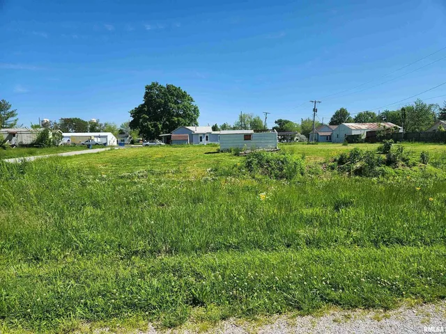 a view of a green field with lots of bushes