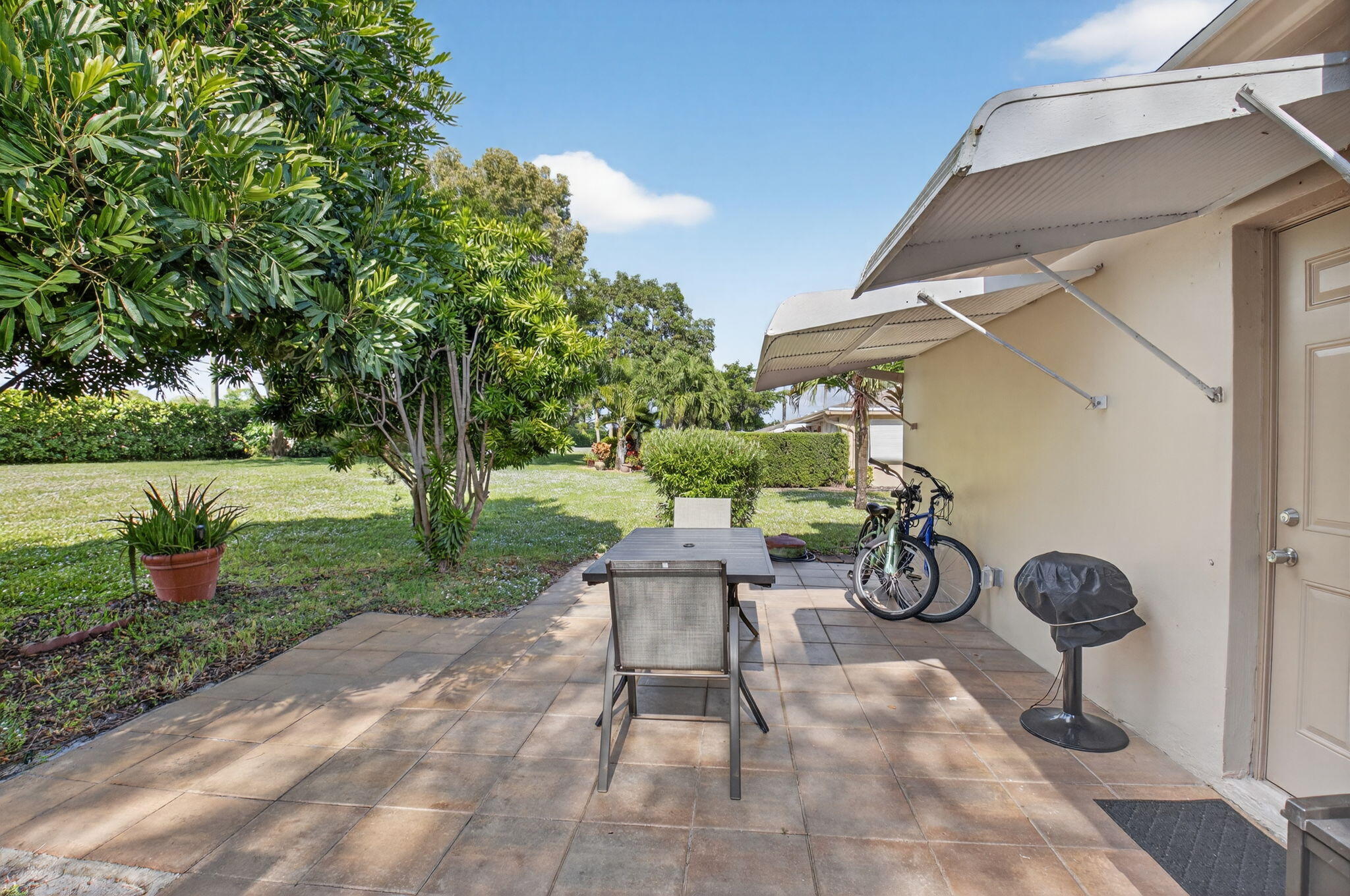 1390 High Point Way Southwest, Unit D Delray Beach, FL 33445 - Photo 20 of 39 a view of a chair and table in backyard of the house