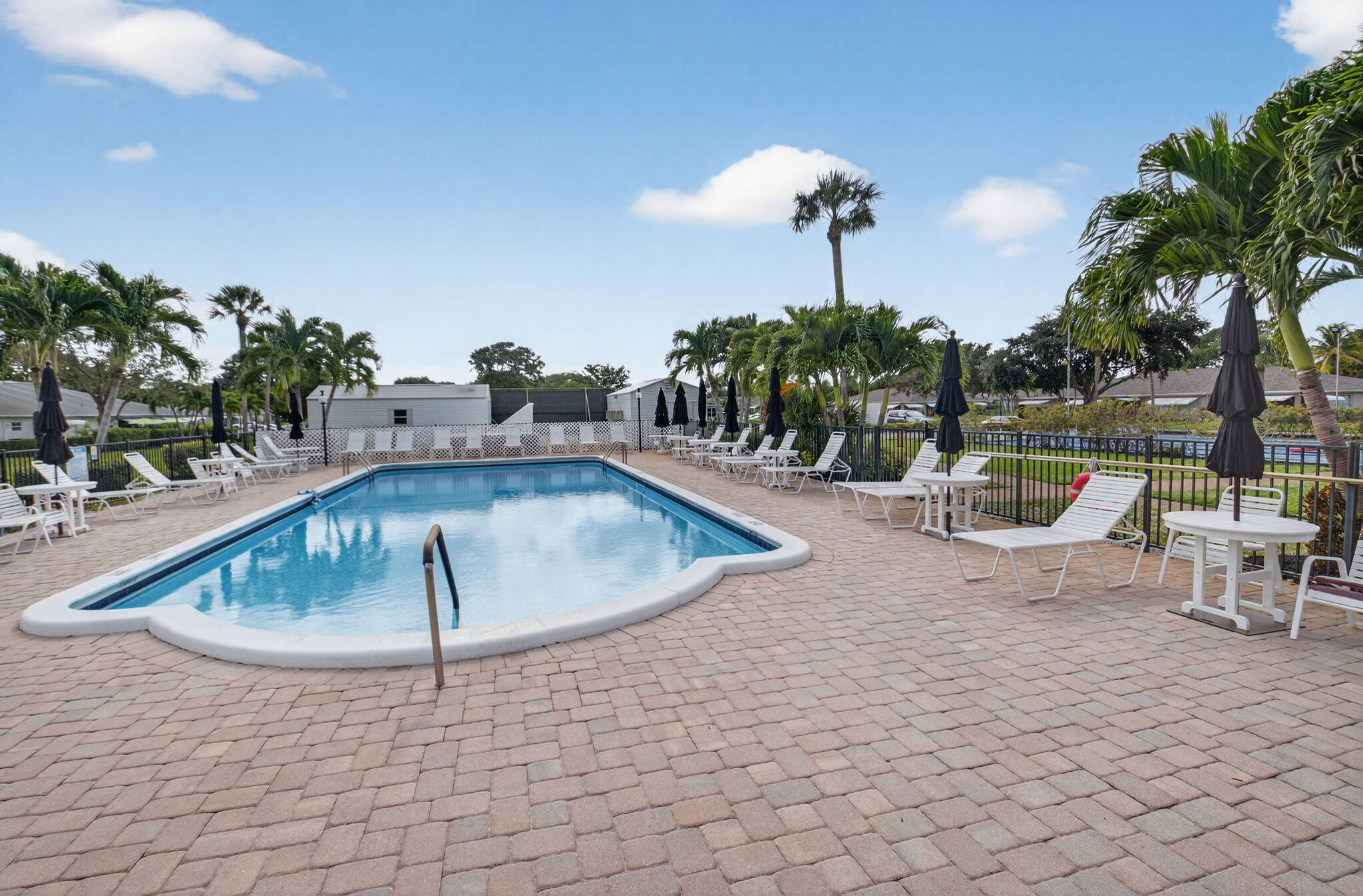 1390 High Point Way Southwest, Unit D Delray Beach, FL 33445 - Photo 28 of 39 a view of a swimming pool with a patio and a yard