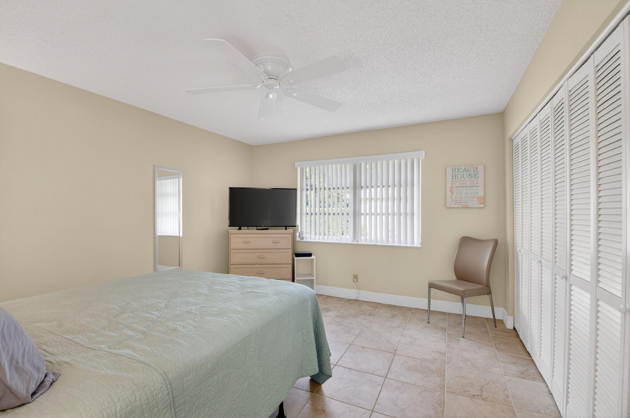 1390 High Point Way Southwest, Unit D Delray Beach, FL 33445 - Photo 9 of 39 a bedroom with a bed and a chair with window