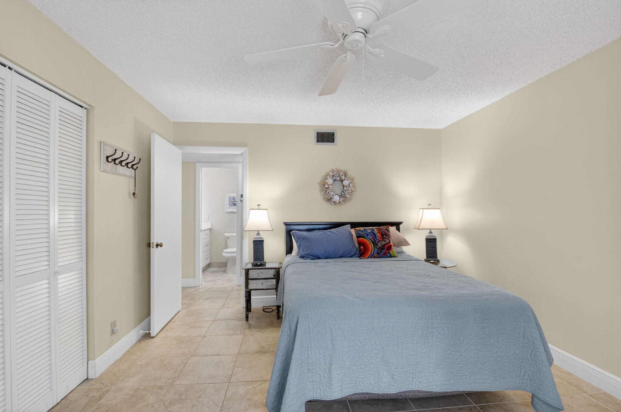 1390 High Point Way Southwest, Unit D Delray Beach, FL 33445 - Photo 10 of 39 a bedroom with a bed and a chandelier