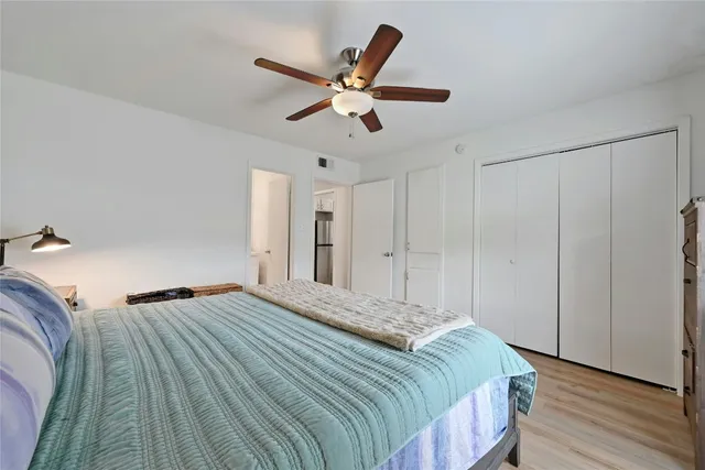 a bedroom with a bed and a ceiling fan