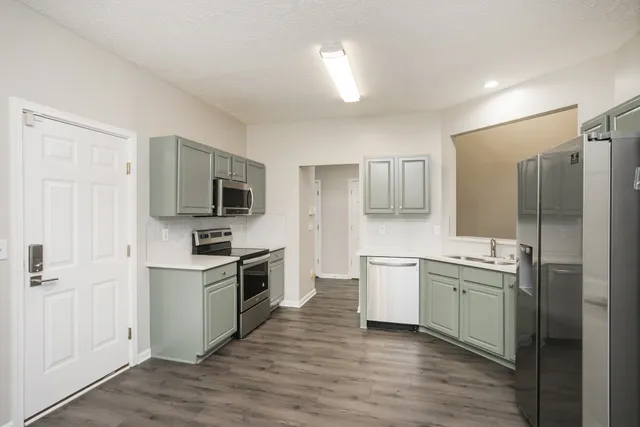 a kitchen with a sink stove top oven and refrigerator