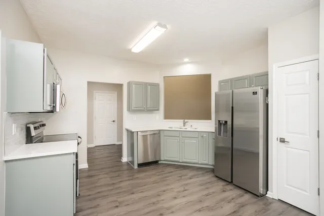 a kitchen with stainless steel appliances a refrigerator sink and microwave