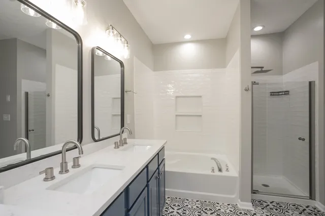 a bathroom with a bathtub shower sink vanity and a mirror