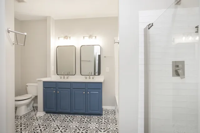 a bathroom with a granite countertop sink a toilet and a mirror