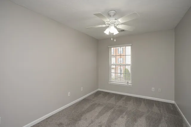 an empty room with a fan and a fan