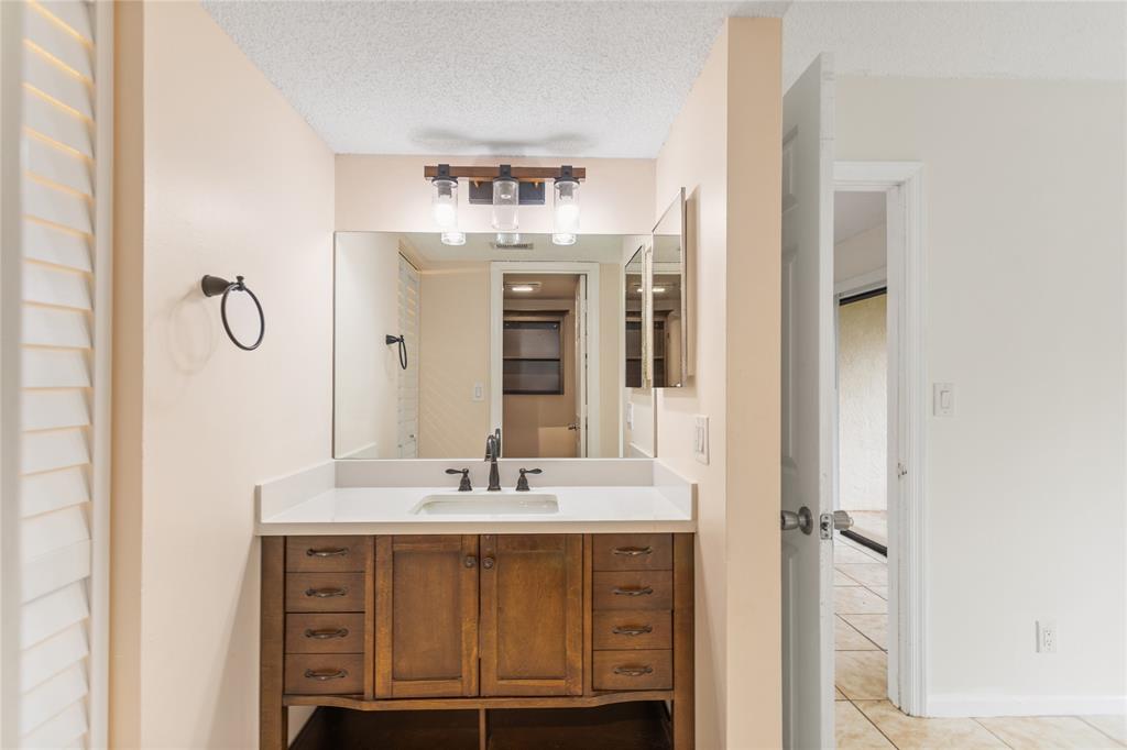 3130 Millwood Terrace, Unit 115 Boca Raton, FL 33431 - Photo 18 of 34 a bathroom with a sink and a mirror