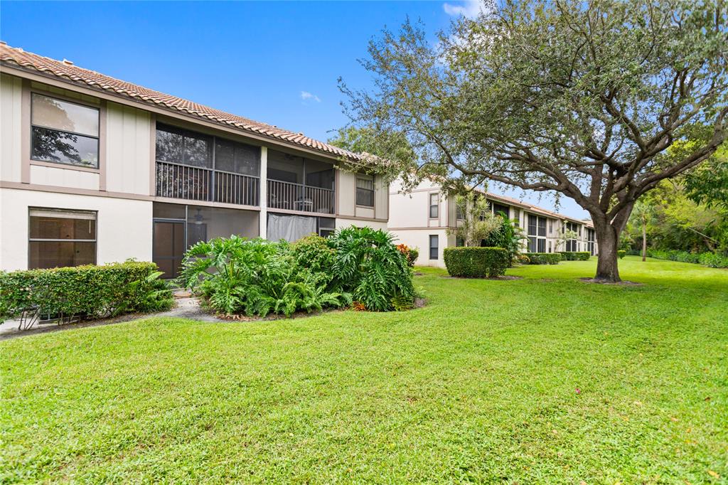 3130 Millwood Terrace, Unit 115 Boca Raton, FL 33431 - Photo 28 of 34 a front view of a house with garden