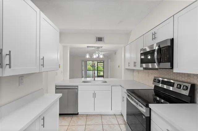 a kitchen with stainless steel appliances white cabinets and a sink