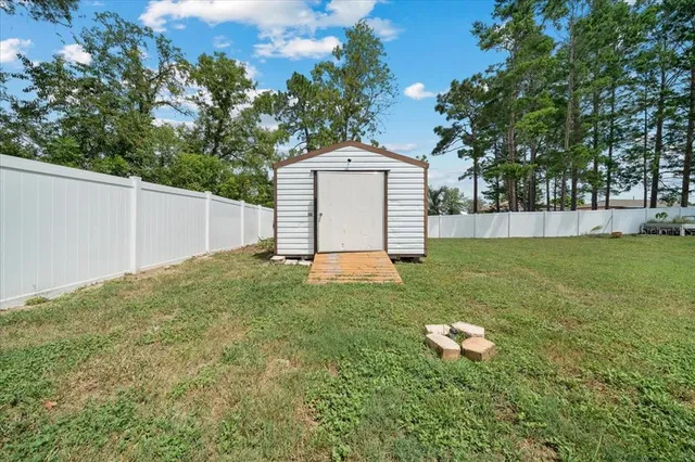 a large white kitchen with stainless steel appliances kitchen island a stove a refrigerator a oven and a refrigerator with wooden floor