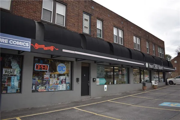 a front view of multi story building with retail shops