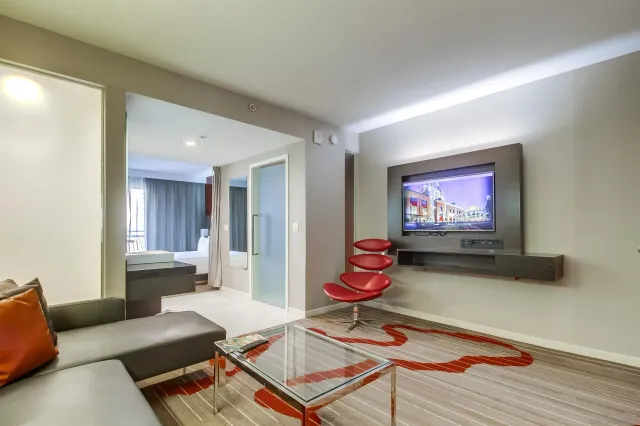 a living room with furniture a flat screen tv and a window