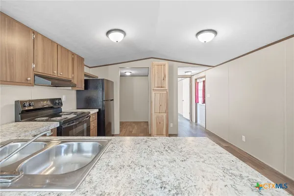 a bathroom with a granite countertop sink a mirror and shower