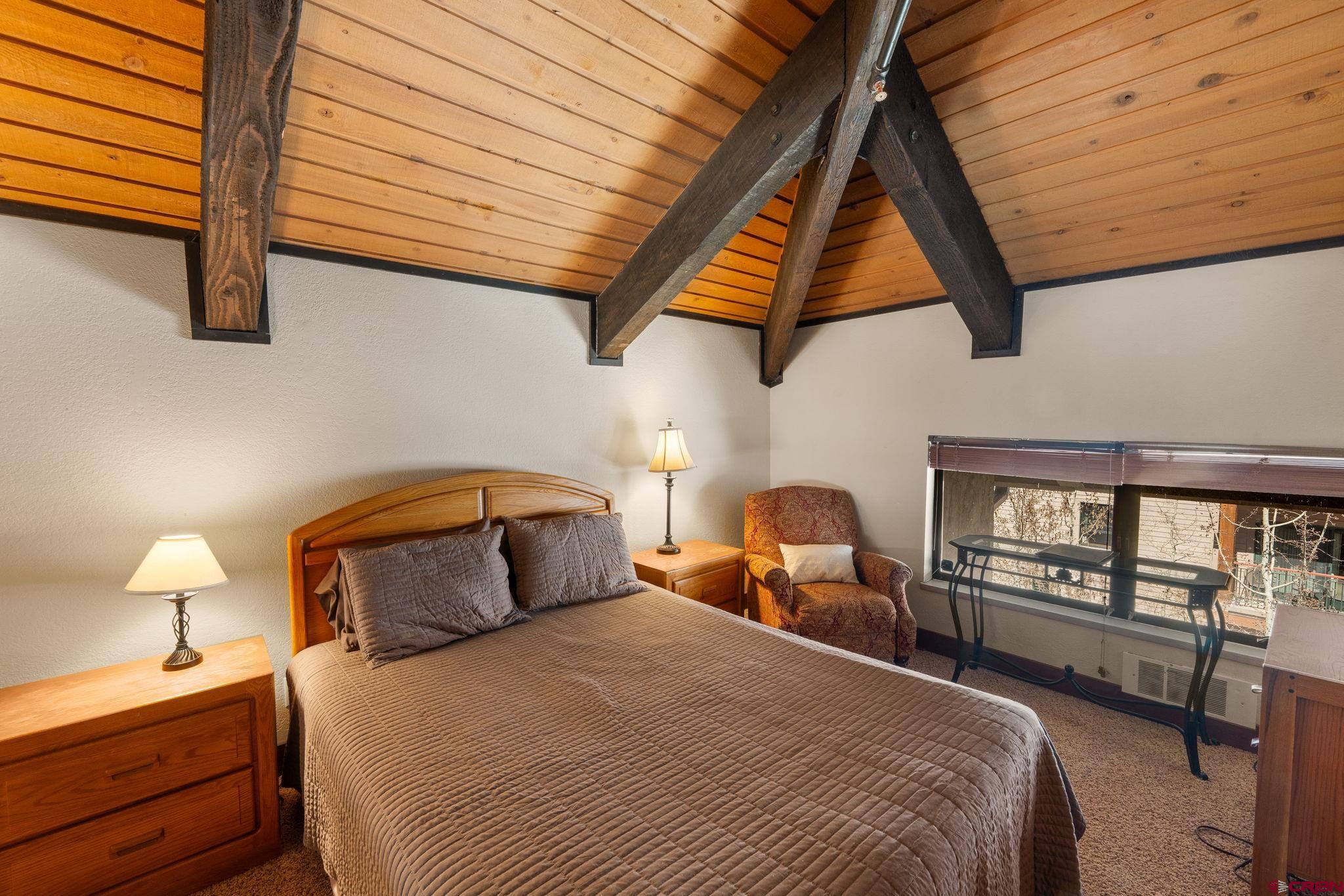 11 Emmons Road, Unit 433 Crested Butte, CO 81225 - Photo 15 of 32 a bedroom with a bed and wooden floor