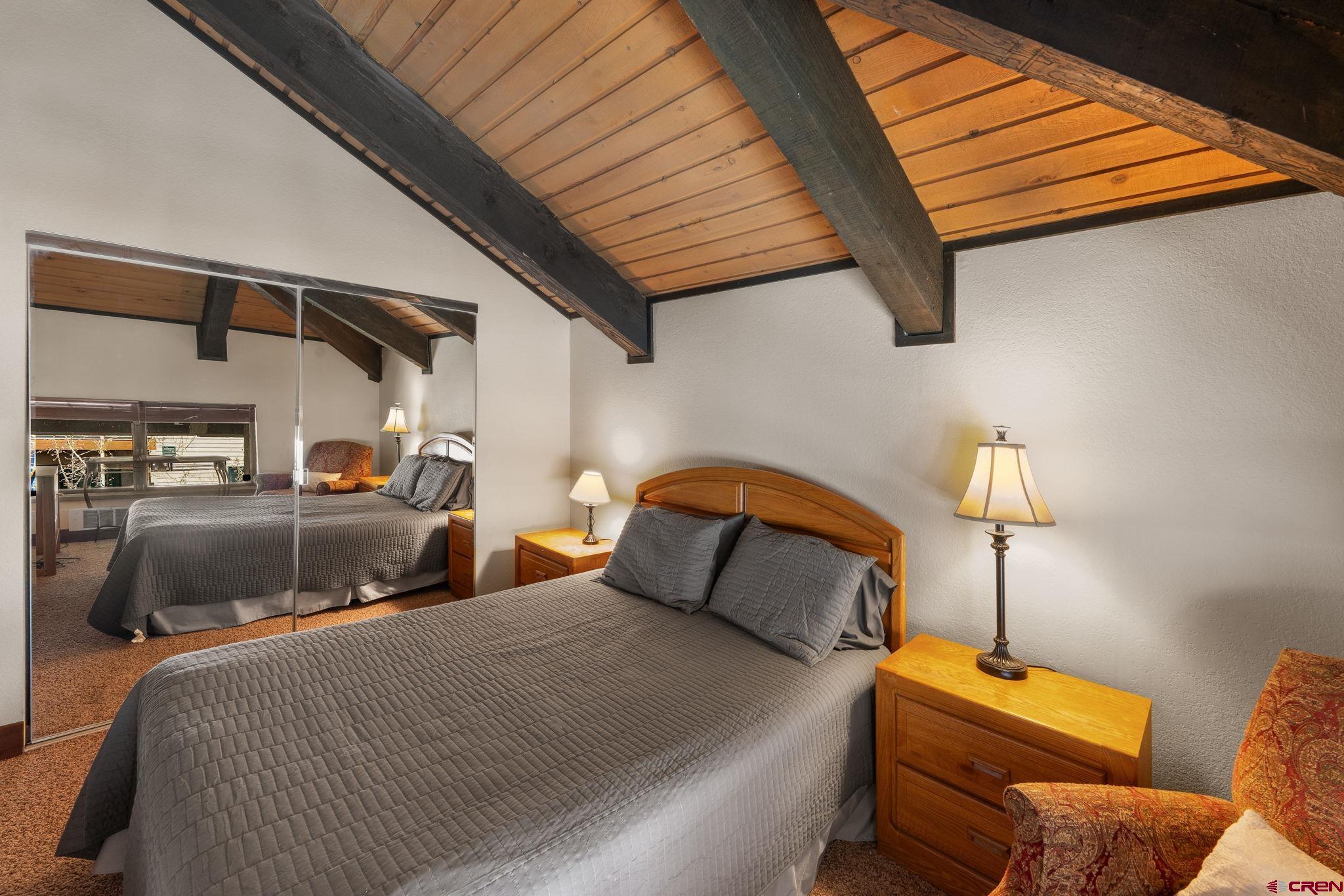 11 Emmons Road, Unit 433 Crested Butte, CO 81225 - Photo 16 of 32 a bedroom with a bed and a lamp