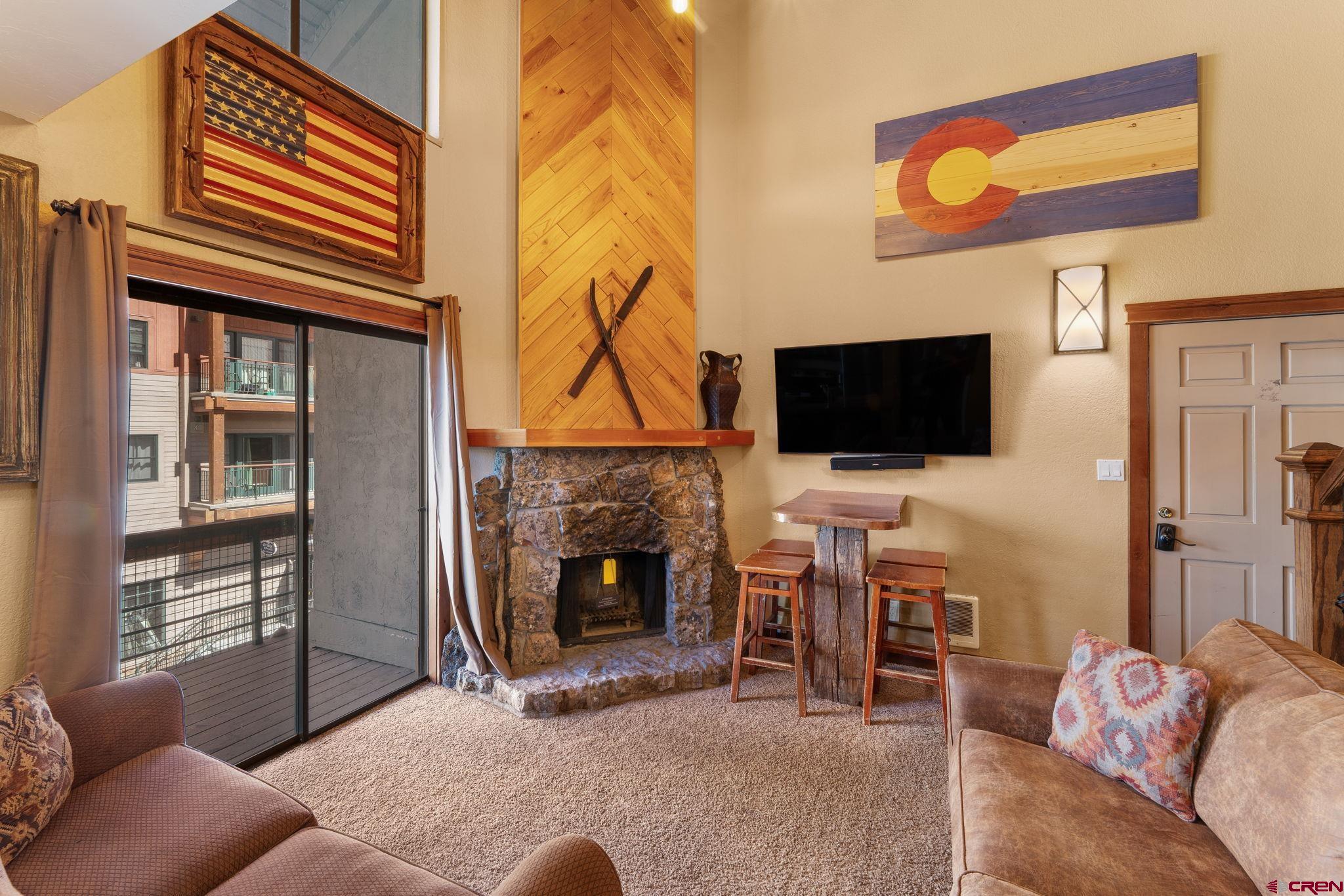 11 Emmons Road, Unit 433 Crested Butte, CO 81225 - Photo 4 of 32 a living room with furniture and a flat screen tv