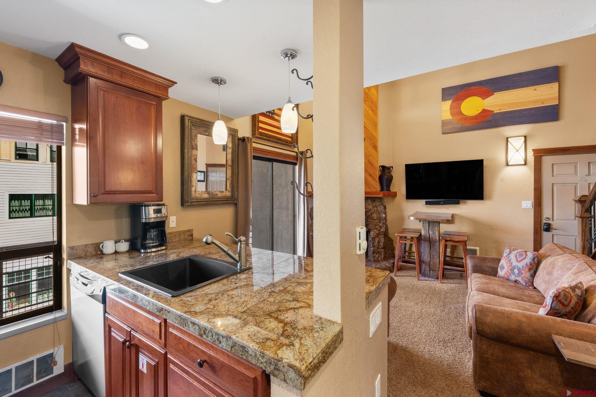 11 Emmons Road, Unit 433 Crested Butte, CO 81225 - Photo 5 of 32 a living room with stainless steel appliances furniture and a flat screen tv