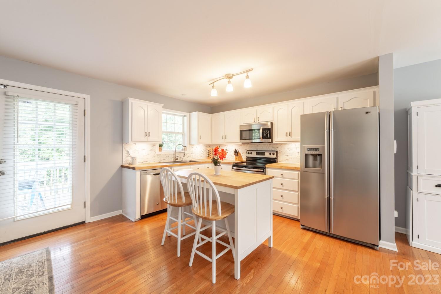 327 Unity Church Road Kings Mountain, NC 28086 - Photo 6 of 30 a kitchen with stainless steel appliances a refrigerator a stove a sink dishwasher and white cabinets with wooden floor