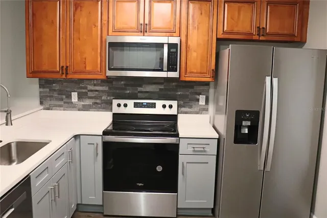 a kitchen with stainless steel appliances granite countertop a refrigerator stove and microwave