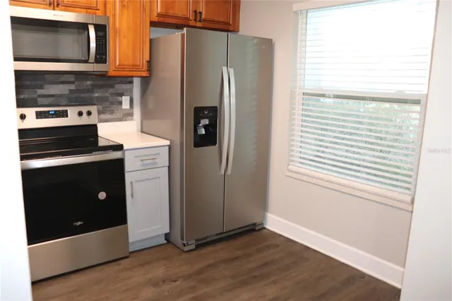 a kitchen with granite countertop a refrigerator and a stove