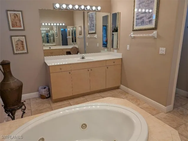 a bathroom with a tub sink and mirror