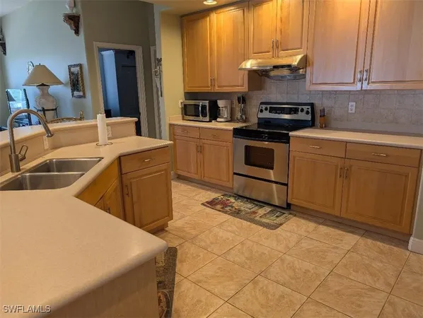 a kitchen with a sink stove and cabinets