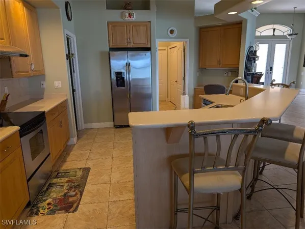 a kitchen with a table chairs refrigerator and microwave