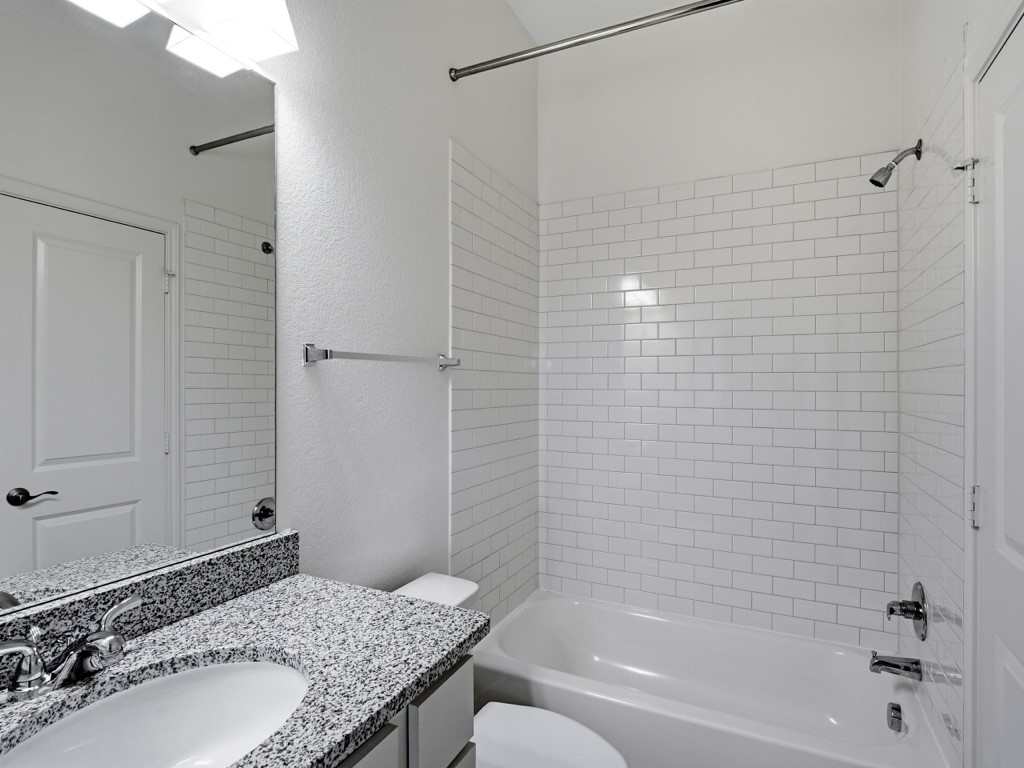 109 Lake Spring Circle Georgetown, TX 78633 - Photo 31 of 38 A well-appointed third bathroom features subway tile surrounding the tub and a spacious vanity with granite counters.